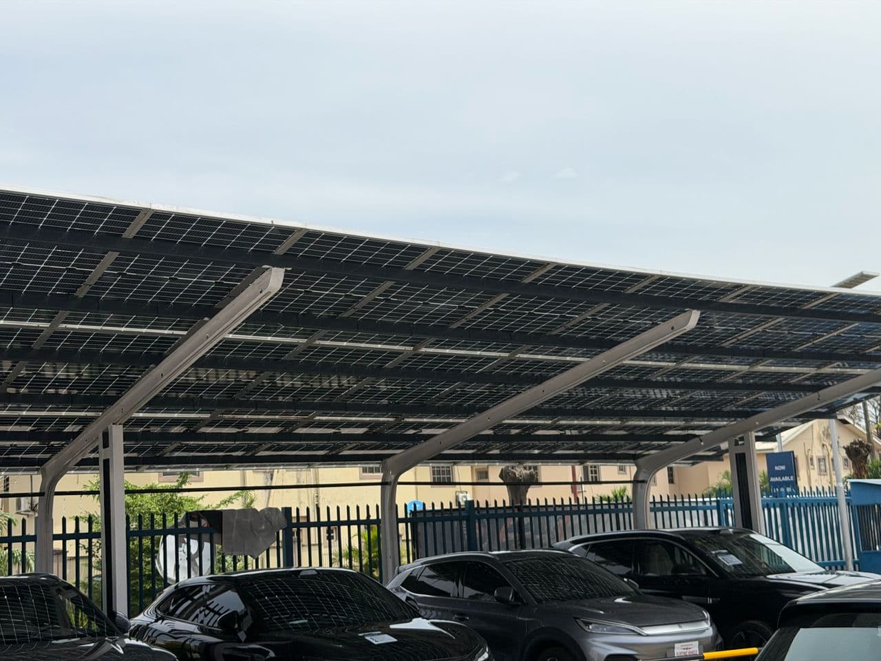 Solar carport canopy shading electric vehicles at a Blue Point charging site in Lagos